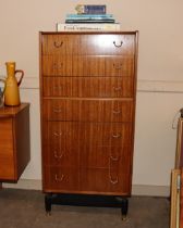 A teak G-plan tall boy chest fitted seven drawers, raised on black supports with brassed feet,