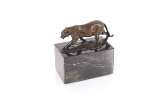 A bronze figure of a prowling big cat, raised on m