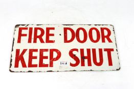 A "Fire Door Keep Shut" sign, red painting on whit