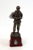 A bronzed resin figure of soldier on plinth with a