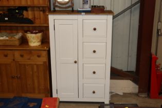 A modern pine cupboard fitted four drawers