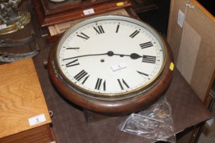 A circular oak cased two hole wall clock with key