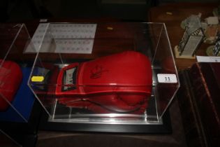 A cased boxing glove with signature
