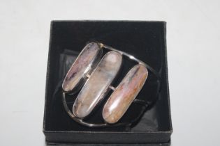 A silver and polished stone bangle