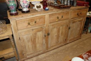 A stripped pine kitchen sideboard fitted three dra