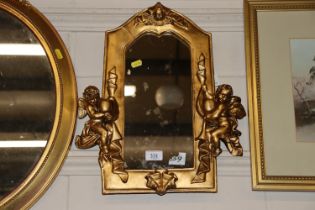 A gilt framed mirror of small proportions decorate