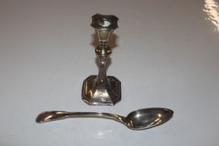 A silver candlestick with filled base; and a white