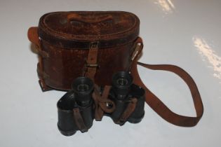 A pair of military marked binoculars with leather