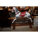 A painted rocking horse on wooden stand