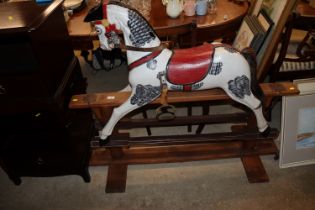 A painted rocking horse on wooden stand