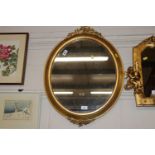 A gilt framed decorative wall mirror with vine dec