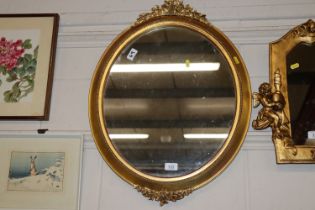 A gilt framed decorative wall mirror with vine dec