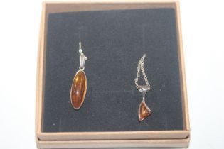 Two Sterling silver an amber pendants