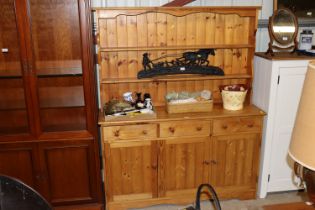 A pine dresser raised on cupboard base fitted three drawers