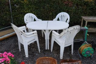 A plastic garden table and eight chairs