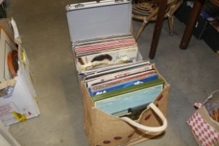 A carrying case of vinyl LPs and a bag of LPs