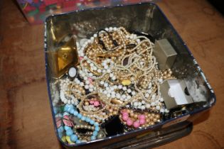 A tin containing various costume jewellery to incl