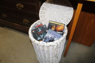 A wicker linen basket and contents of DVDs