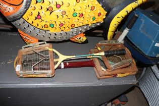 A vintage tennis racket and two squash rackets