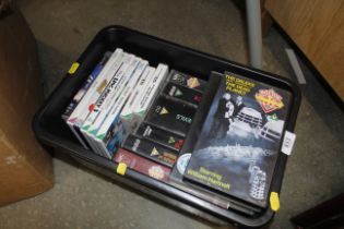 A box containing various video games and VHS tapes