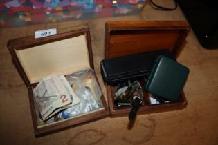 Two wooden trinket boxes containing various coinag