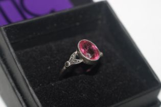 A white metal ring set marcasite and pink coloured