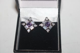 A pair of silver ear-rings set with amethyst colou