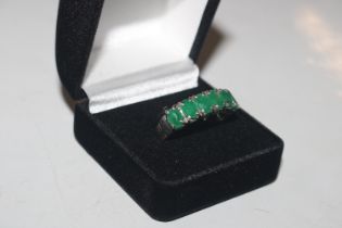 A 925 silver ring set with emerald coloured stones