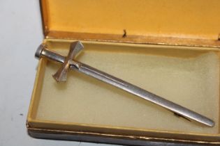A silver brooch in the form of a sword
