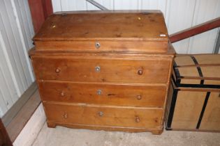 A large pine bureau fitted three long drawers