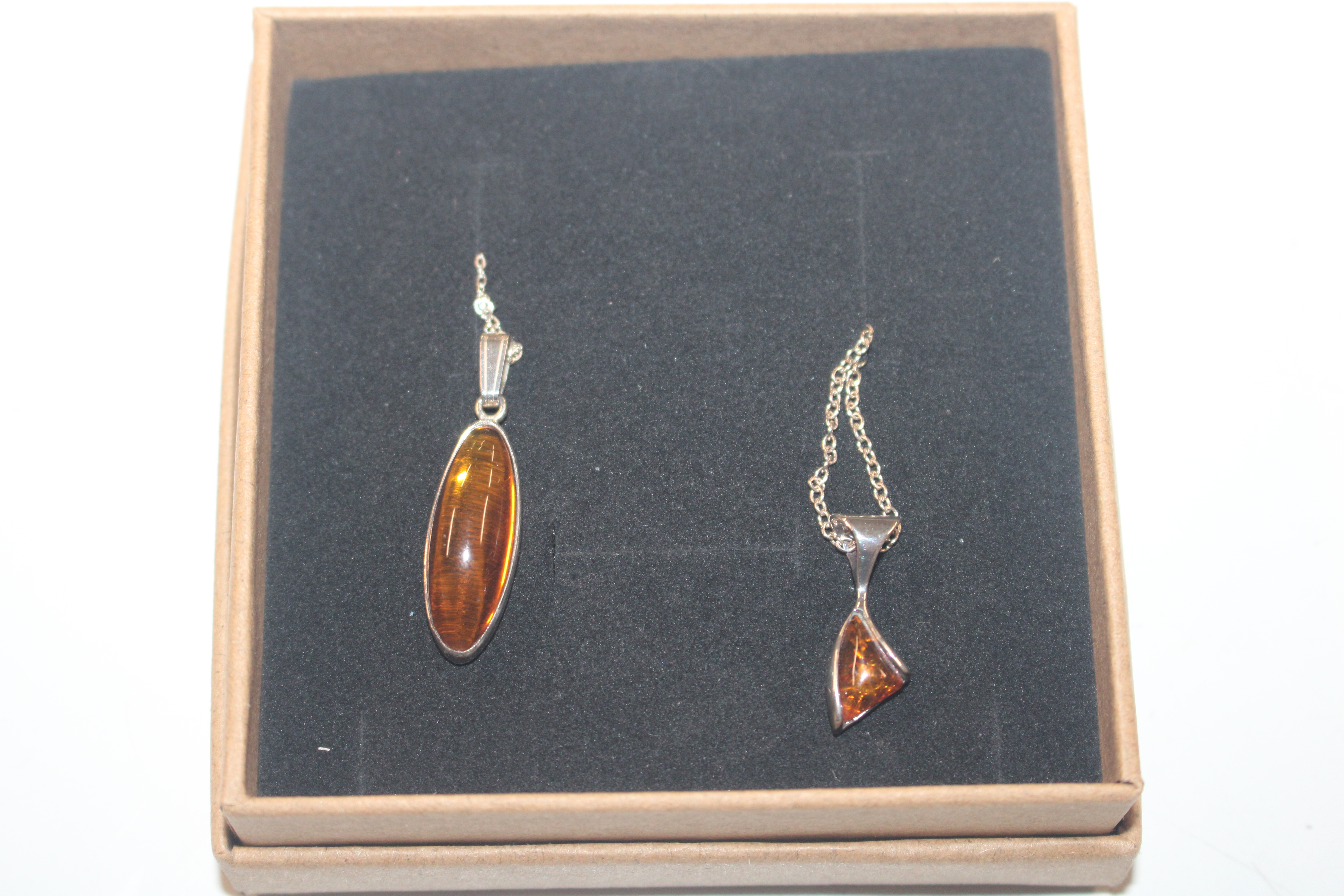 Two Sterling silver and amber pendants