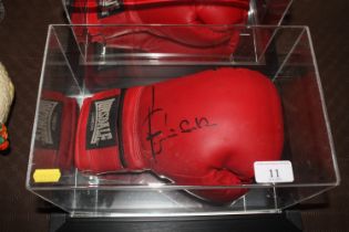 A cased boxing glove with signature
