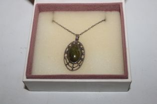 A silver pendant set with green agate hung to fine