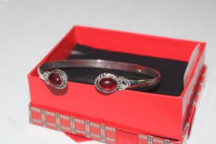 A 925 silver bangle set with red stones