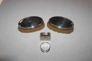 Two silver backed brushes and two silver napkin ri