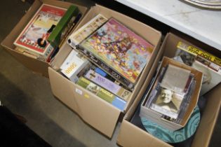 Three boxes containing various games, jigsaw puzzl