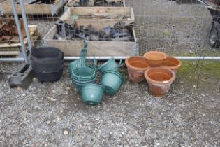 Four plant pots; a quantity of plastic pots and pl