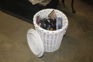 A wicker linen basket and contents of various DVDs