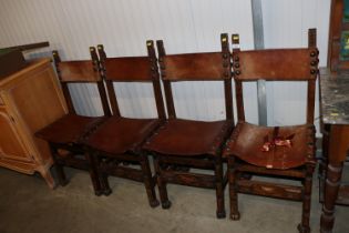 A set of four carved wooden and leather upholstere