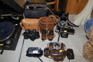 A quantity of various cameras and binoculars inclu