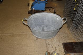 A galvanised twin handled bath