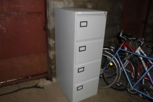 A metal four drawer filing cabinet with keys