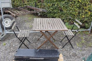 A metal and wooden folding garden table and two ch