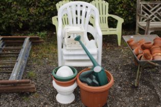 Three plastic garden chairs; two watering cans and