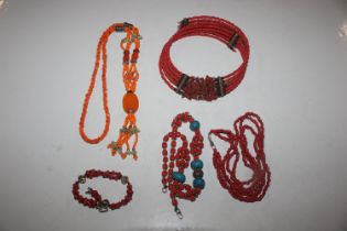 A tray of coral and other necklaces