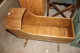An antique stripped pine cradle