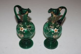 A pair of Victorian green glass ewers