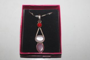 A silver and rose quartz pendant on silver chain