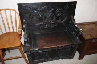 A carved oak monks bench