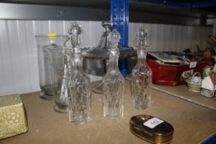 A glass cake stand; glass cruet bottles; a brass b